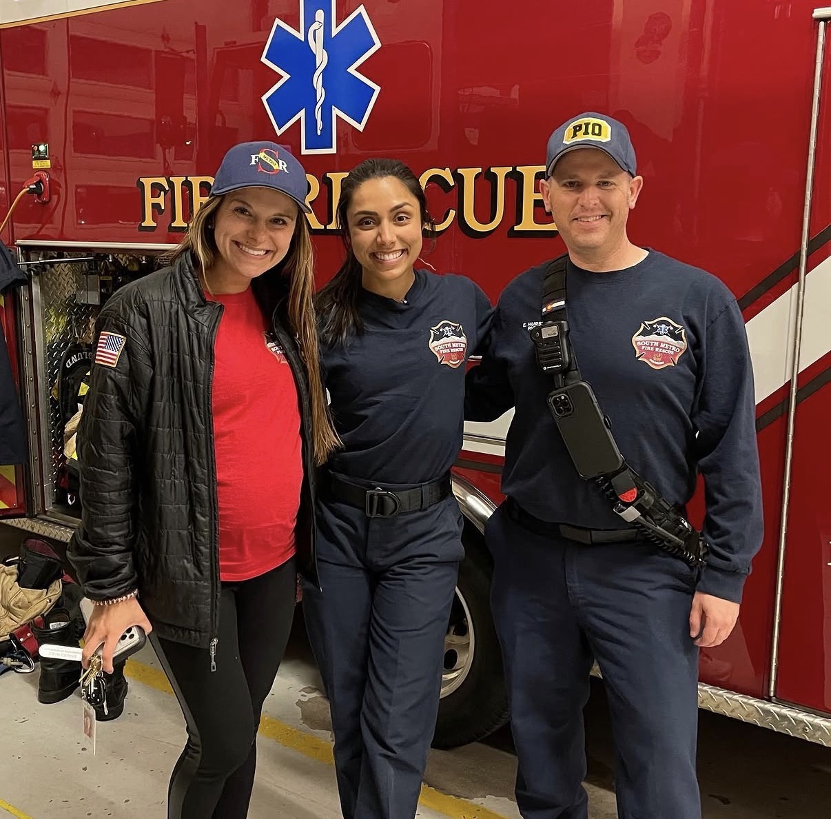 Connor Christian, Michelle Khare, and Eric Hurst beside a fire rescue vehicle