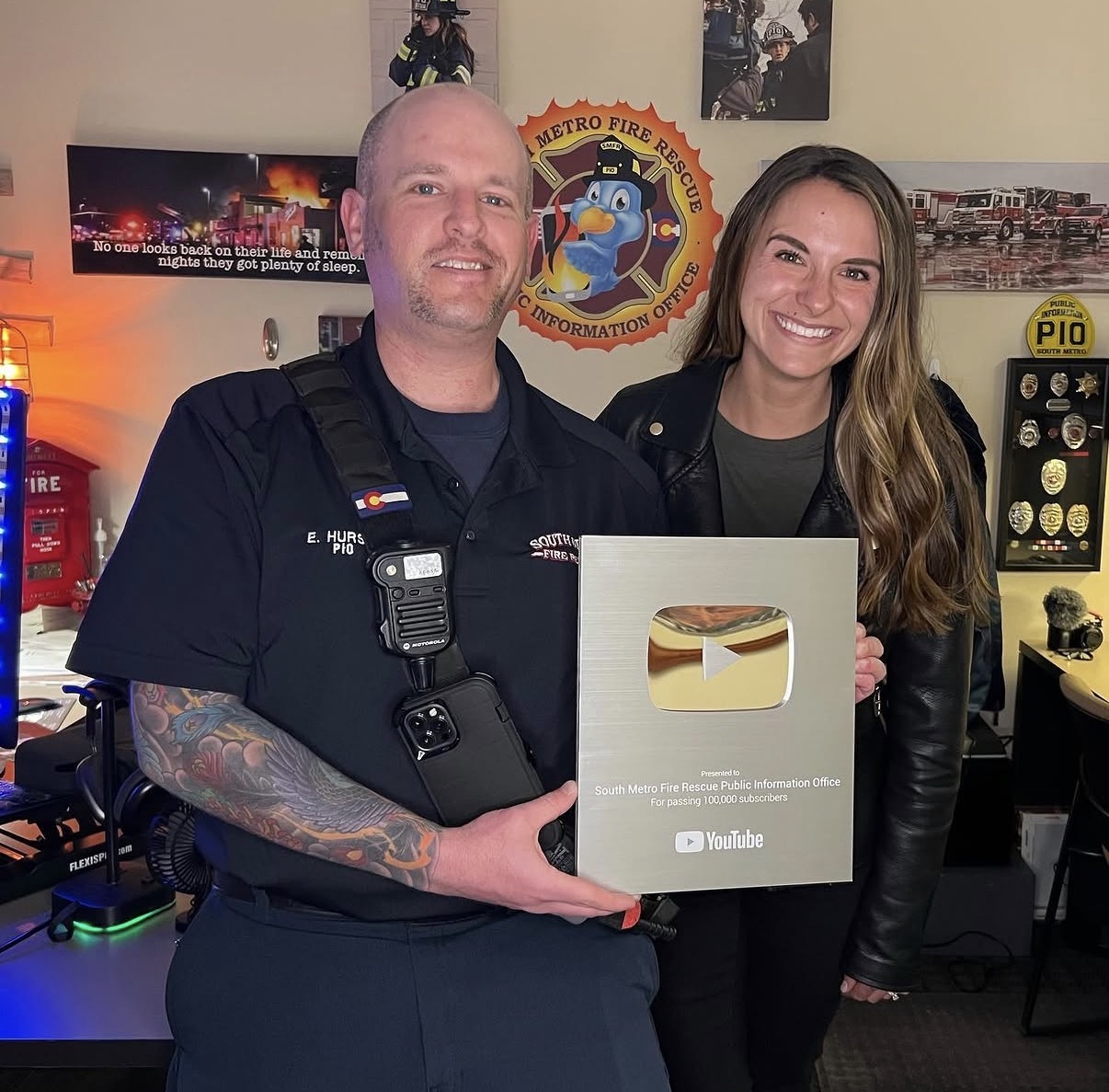 Eric Hurst and a colleague holding South Metro Fire Rescue’s YouTube Silver Creator Award